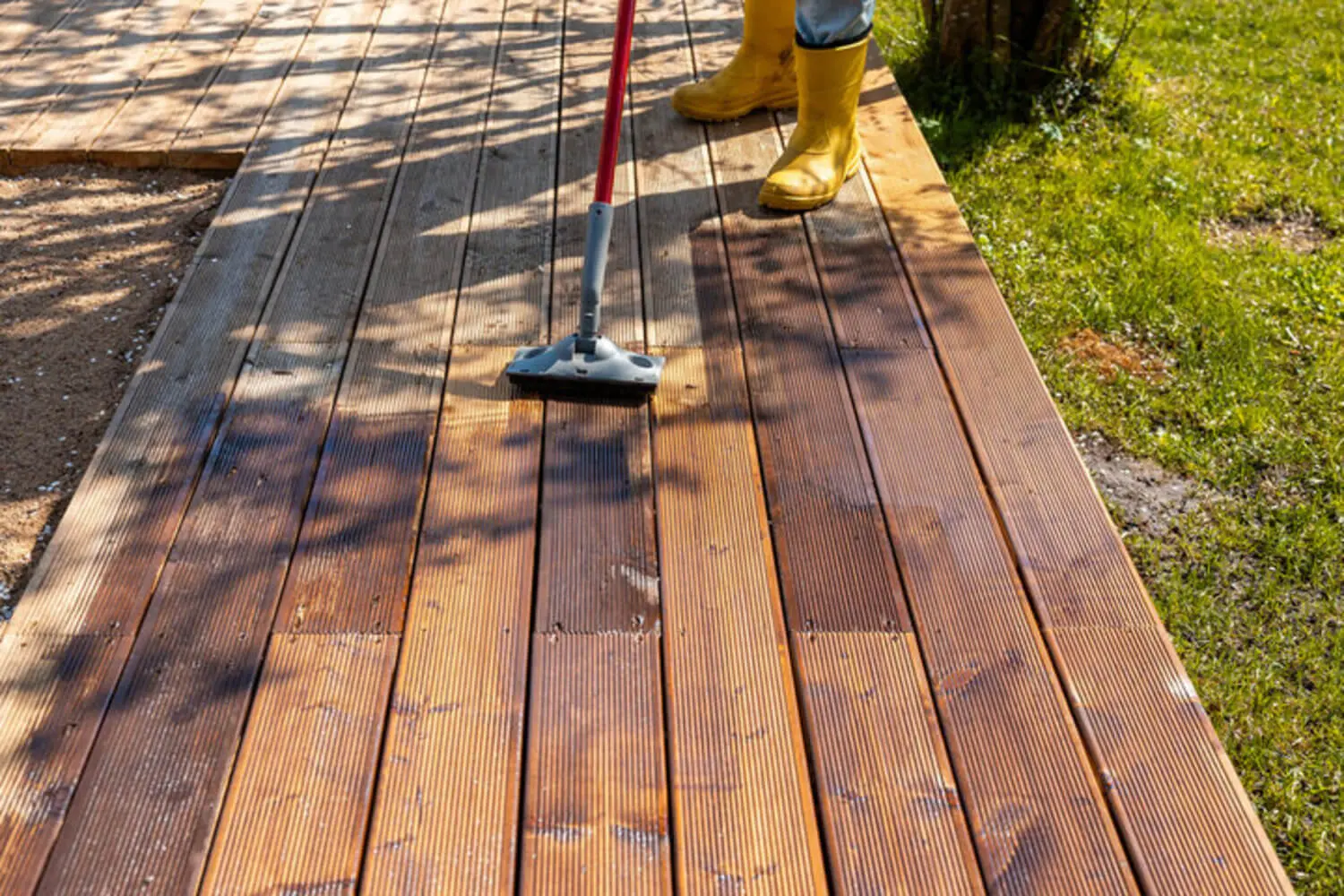 Applying deck stain to a wood deck, a process affected by humidity in Jacksonville Beach's coastal climate.