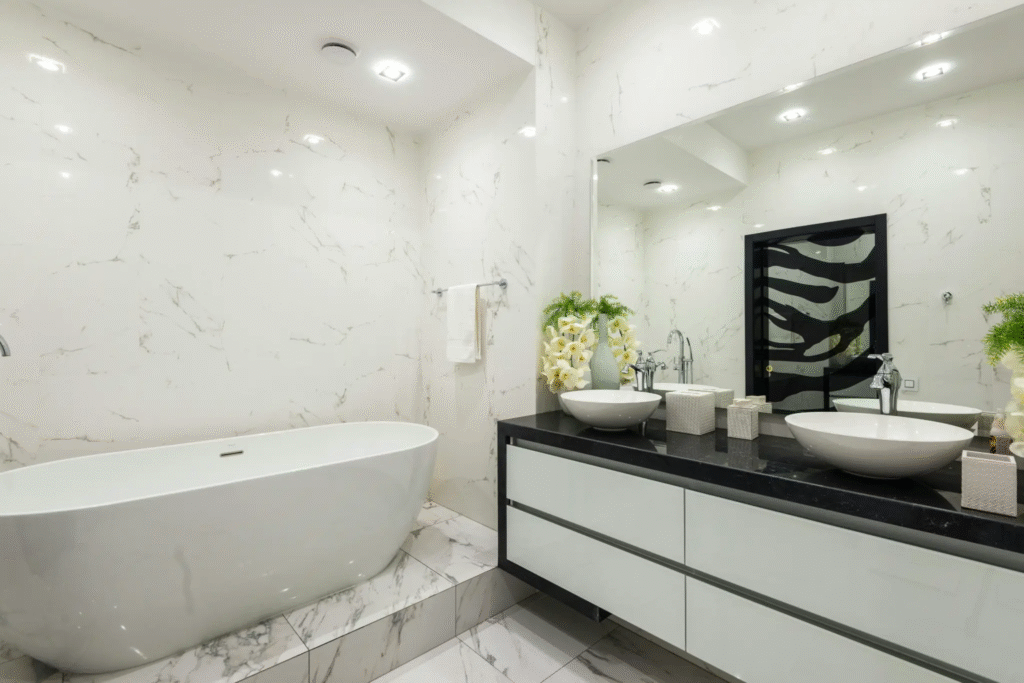 A luxurious bathroom with marble walls and a black double vanity. Spray paint bathroom fixtures to match any design.
