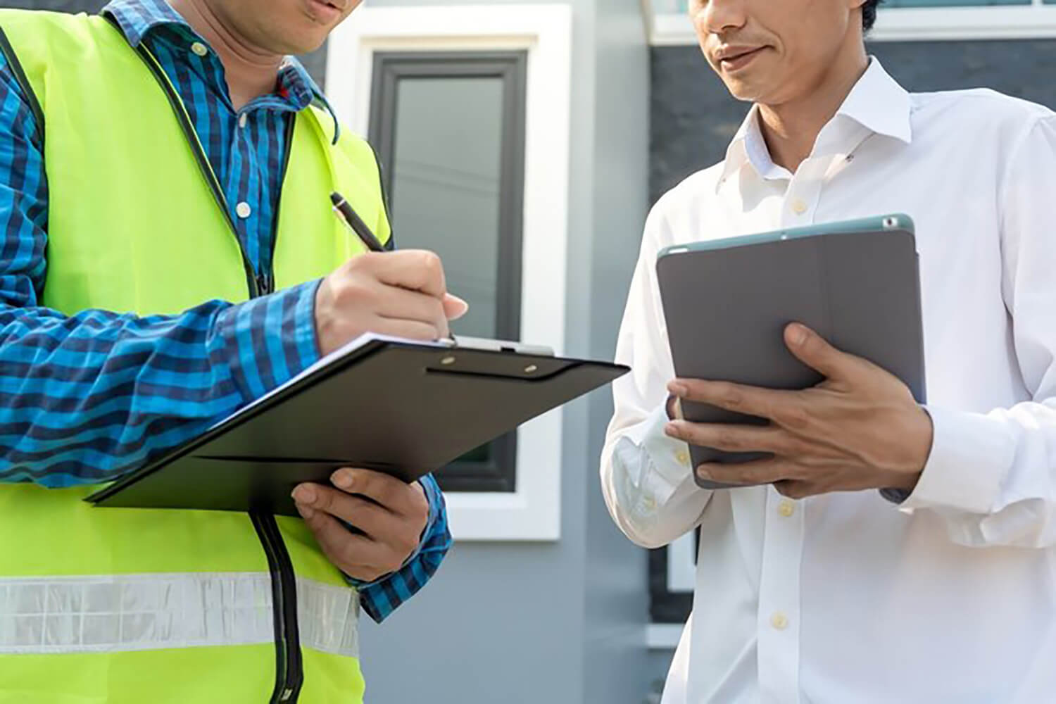 Homeowner reviewing a written quote with a contractor, an important step in spotting red flags when hiring a painting contractor.
