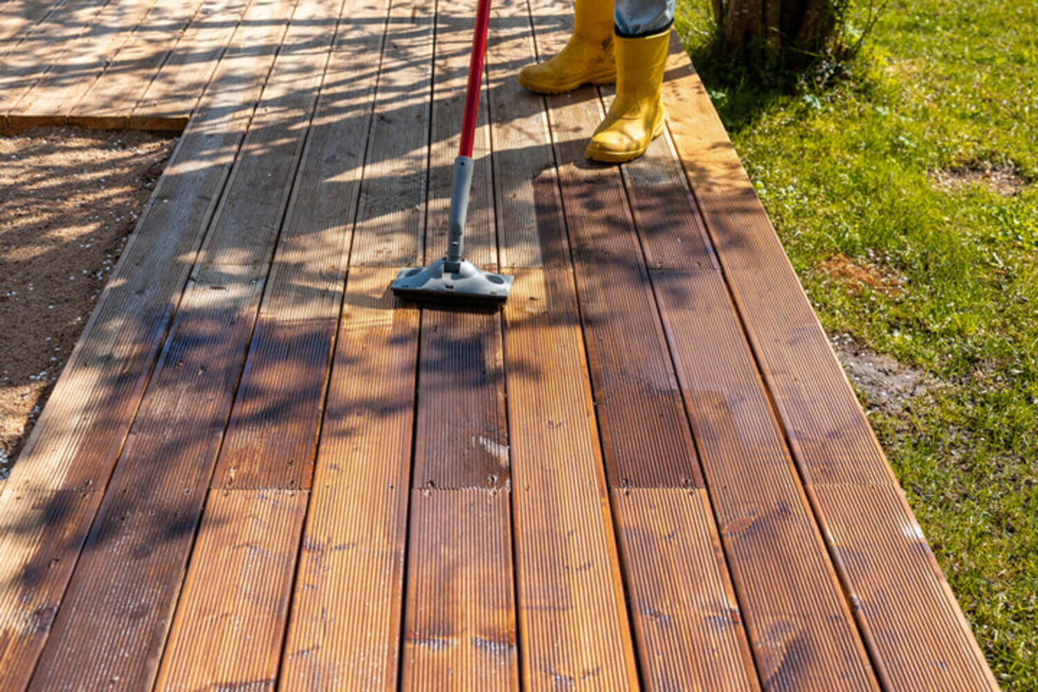 Applying deck stain to a wood deck, a process affected by humidity in Jacksonville Beach's coastal climate.